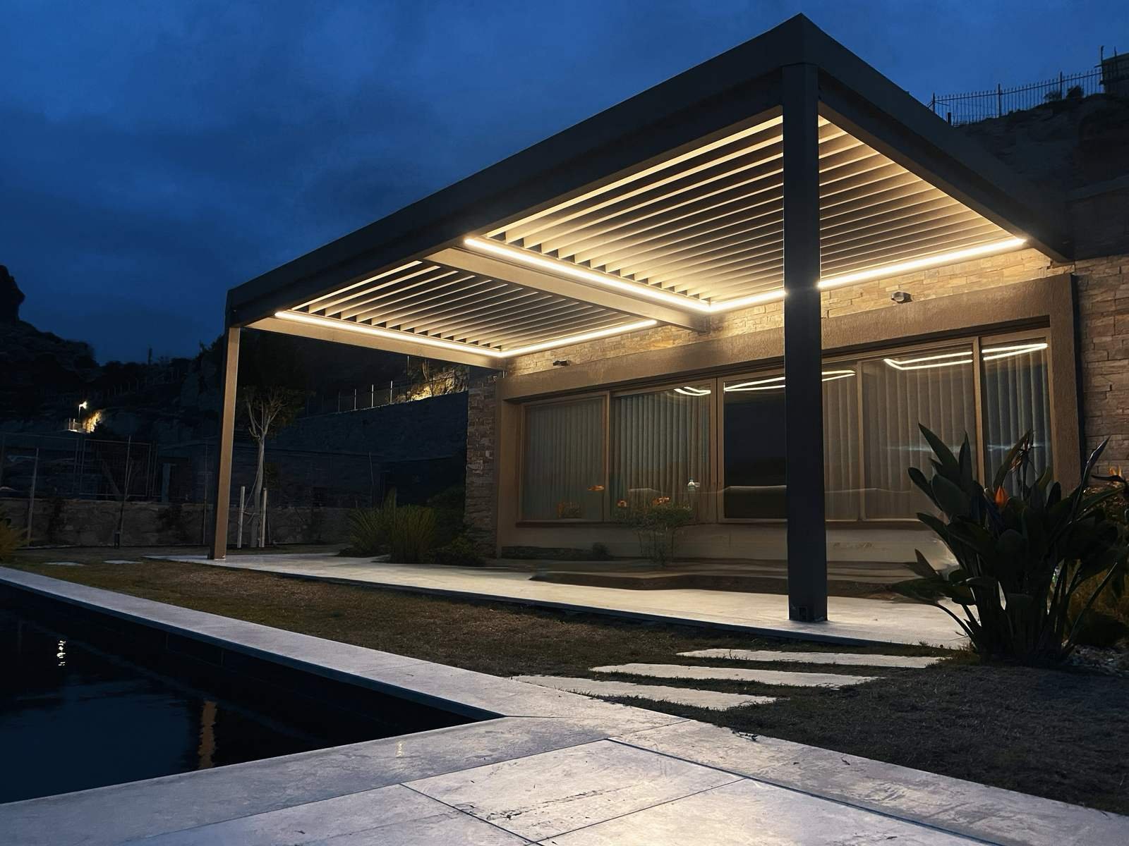 Gece, havuz başında LED aydınlatmalı biyoklimatik pergola
