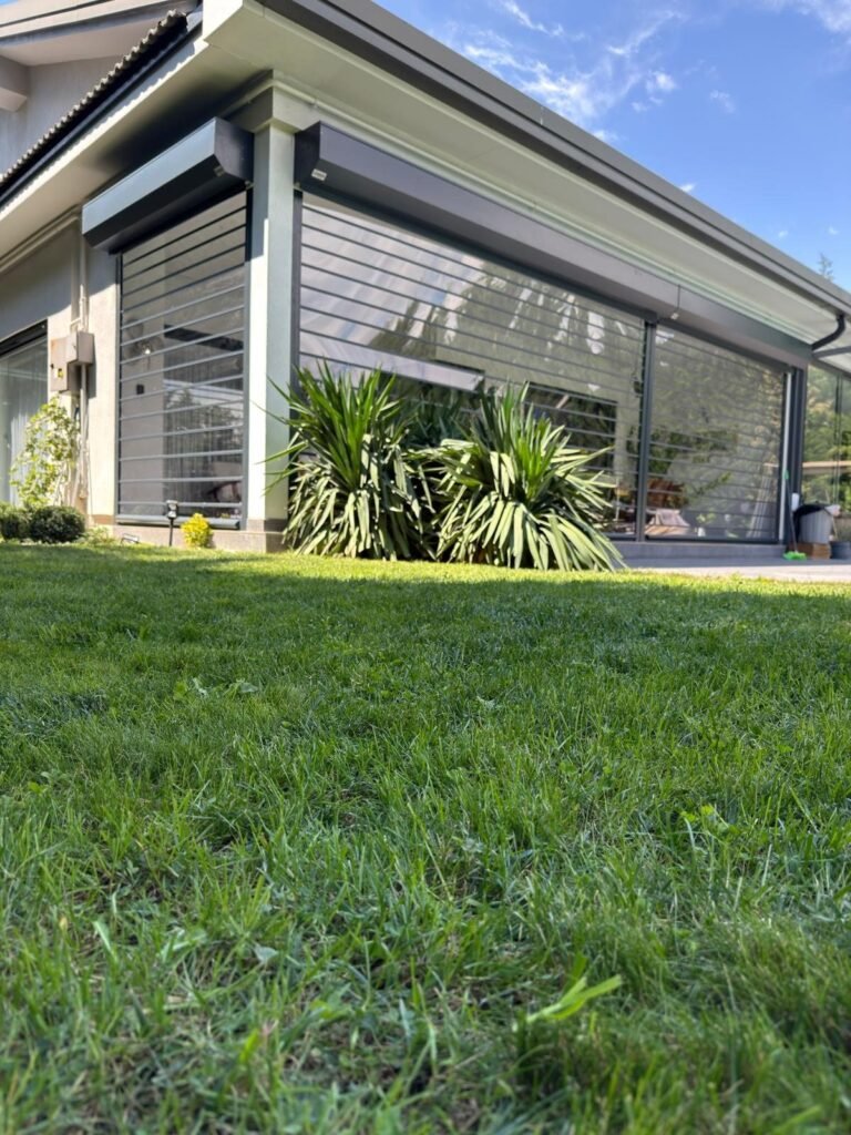Villa terasının iki cephesini kapatan antrasit şeffaf kepenk sistemi